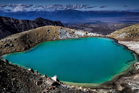 The emerald green lake is nestled in a barren volcanic landscape, Tongariro National Park, New