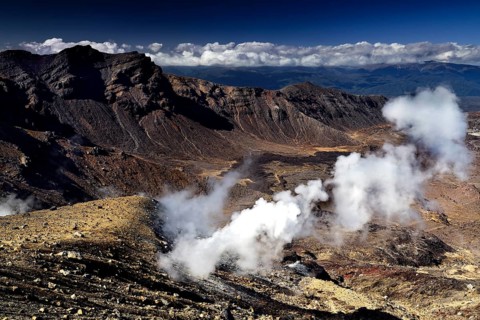 Solfatars escape steaming from the rocky landscape with views of the Emerald Lakes, Tongariro