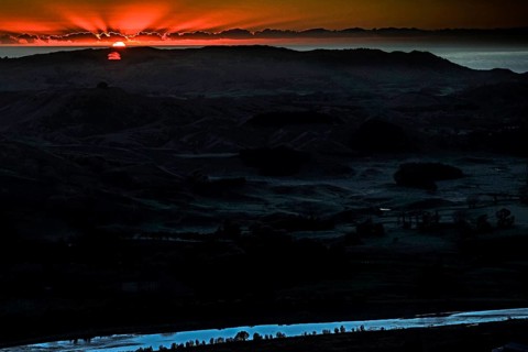 Dramatic sunrise behind mountain landscape with intense colors, Te Mata Peak, New Zealand
