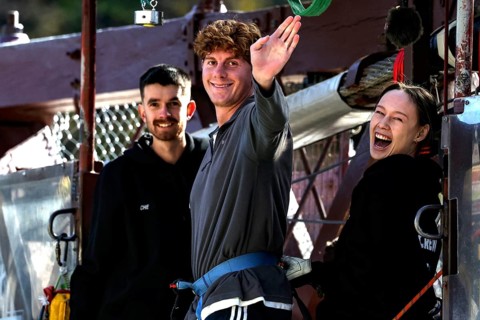 Person in front of bungee jump smiling surrounded by friends at Kawarau Bridge, Queenstown, Kawarau