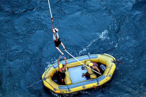 Bungee jumper is stopped over a yellow inflatable boat in the river, Queenstown, Otago, New Zealand