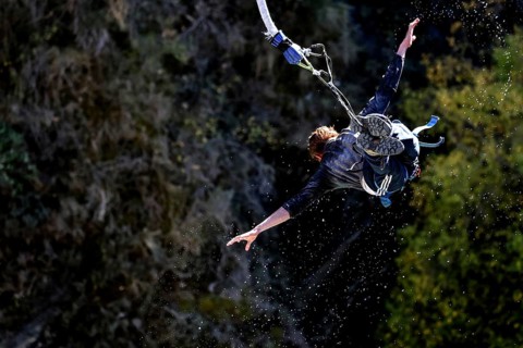 Person in a spread flight position bungee jumping over the countryside, Queenstown, Kawarau Bridge,