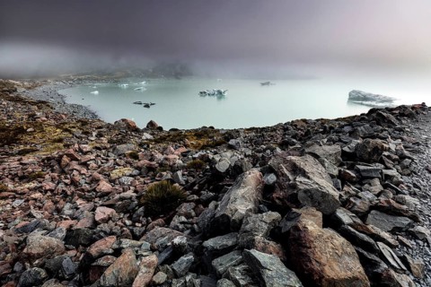 Cold glacial lake on Hocker Valley Track with rugged rocks and fog, Mt Cook, Hocker Valley Track,