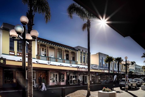 Art Deco street scene with flare sun effect and palm trees, Napier, Hawke's Bay, New Zealand