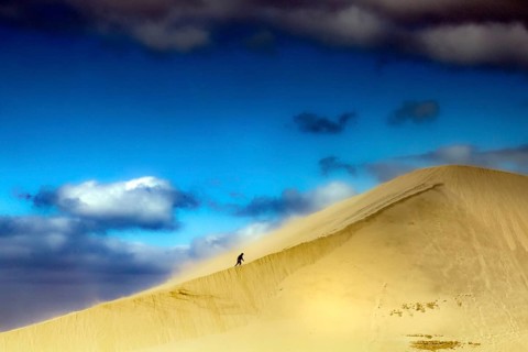 Majestic sand dune under a bright blue sky with clouds, Ninety Mile Beach, Te Paki, New Zealand