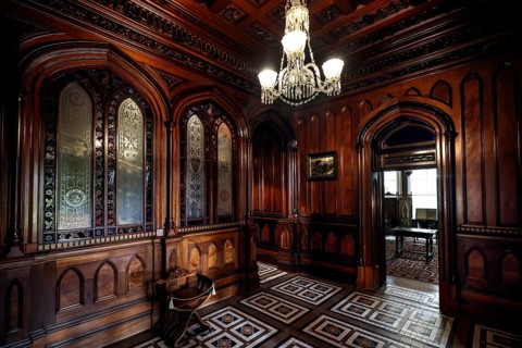 Antique foyer with intricate wood ornaments and a chandelier, Larnach Castle, Otago Peninsula, New