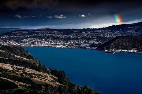 View of Dunedin with rainbow over harbor in beautiful landscape, Dunedin, Otago, New Zealand