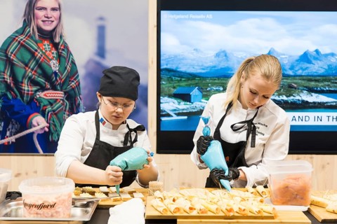Two woman decorate dishes for Norway's stand at Green Week at the exhibition center in Berlin on 16
