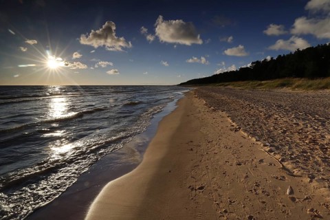 Sunset over sandy beach near Vitrupe, peaceful waves and golden horizon, Vitrupe, Latvia