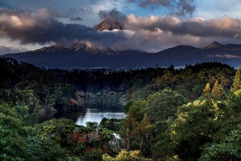 Lake Mangamahoe with Mount Taranaki in the background, surrounded by wooded landscape, New Zealand,