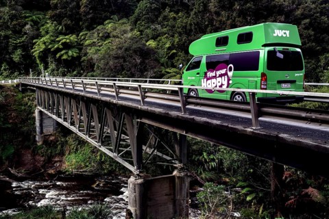 A Jucy camper crosses a bridge across the Tangarakau River on the Forgotten World Highway,