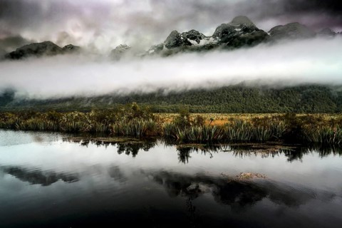 Mountain landscape with dramatic sky is clearly reflected in the calm lake, Mirror Lakes, New