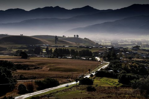 Mountainous landscape with fog covered peaks and an approaching road in Kaikoura, Kaikoura, New