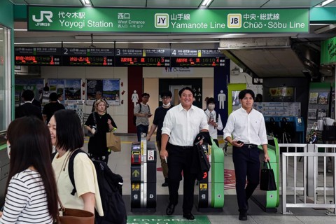Entrance of a busy train station with commuters in Tokyo, Tokyo, Japan