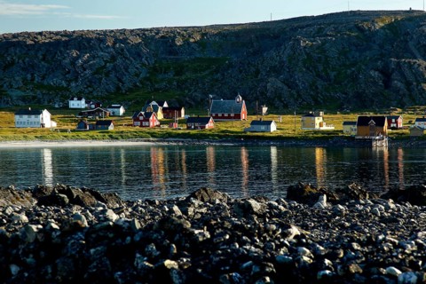 View of Hamningberg with kittiwakes along the coast and reflections in the water