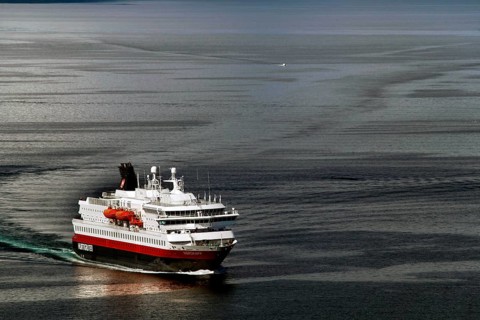 Hurtigruten ferry sails through calm sea near Hammerfest, Hammerfest, Finnmark, Norway