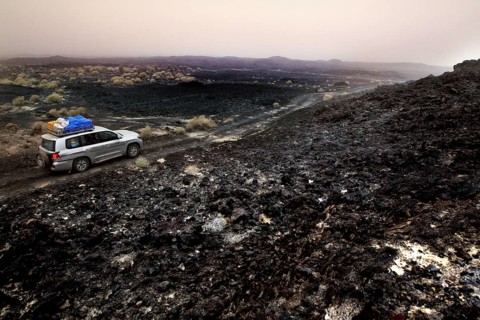 Travel through a barren lava desert with a Landcruiser on a gravel road