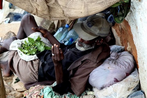 Man relaxes in Harar and consumes khat in improvised shelter, Harar, Oromia, Ethiopia