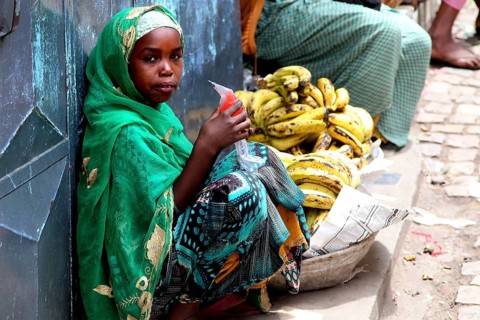 Child banana saleswoman wearing traditional clothes in the old town of Harar, Harar, null