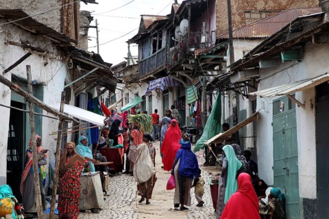 Lively tailor's alley in the old town of Harar filled with people wearing traditional clothes,