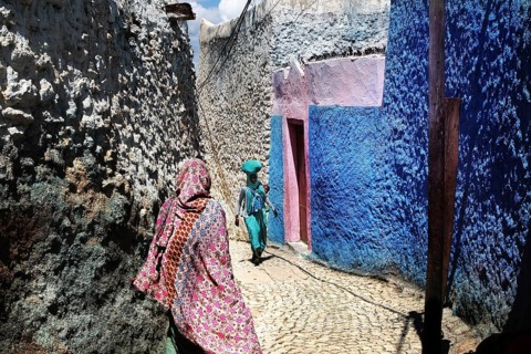 Narrow alley in Harar with eye-catching colors and passers-by, Harar, Ethiopia