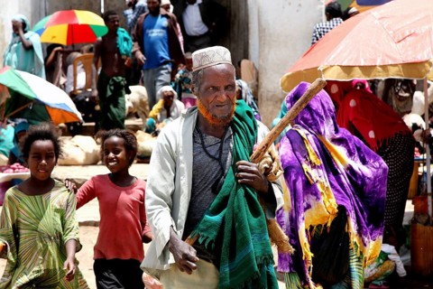 Lively market in Harar with people wearing traditional robes and colorful umbrellas, Harar, Oromia,