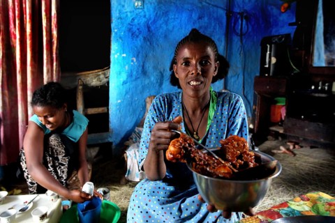 Woman having fun presenting a dish to Chuchu's family in Lalibela, Lalibela, null