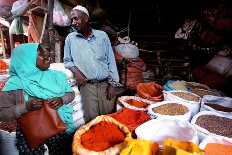 A man and a woman talk at a colorful spice market in Harar, Harar, Harar, Ethiopia