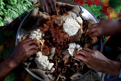 Eating together on a large food platter with Injera with Chuchu's family in Lalibela, Lalibela,