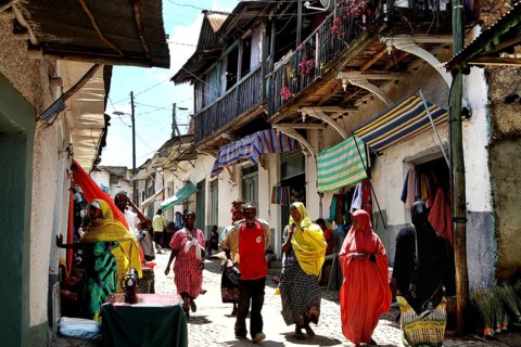 Busy alley in Harar with people in colorful costumes in bright sunshine, Harar, Oromia, Ethiopia