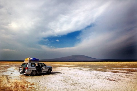 Landcruiser stands in a vast landscape with dramatic skies, zero
