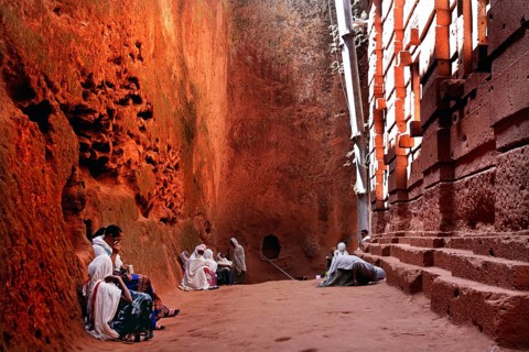 People wearing traditional clothing sit at Bete Emanuel, impressive rock architecture, Lalibela,