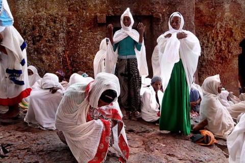 Women wearing white robes pray during Easter at Bete Maryam Church, Lalibela, Amhara, Ethiopia