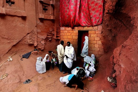 Believers gather in front of the Bete Abba Libanos church under a red cloth, Lalibela, Amhara,