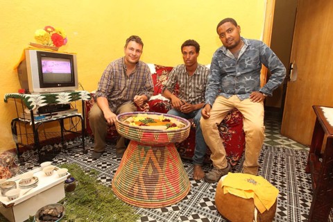 Conversation among men visiting with traditional food, Lalibela, Ethiopia