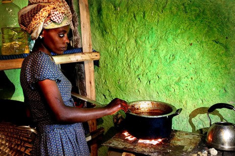 Woman carefully cooks chicken in rural kitchen, Lalibela, Ethiopia