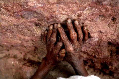 Hands touch a church wall in prayer, expressing deep spirituality, Lalibela, Amhara, Ethiopia
