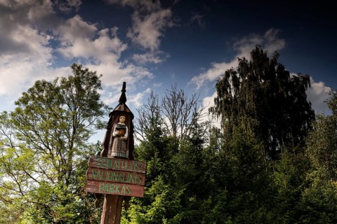 Entrance sign with carved figure in front of trees in Zemaitija National Park, Zemaitija National
