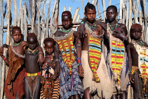 Group of Hamer girls in traditional clothing in front of a fence, Turmi, Ethiopia