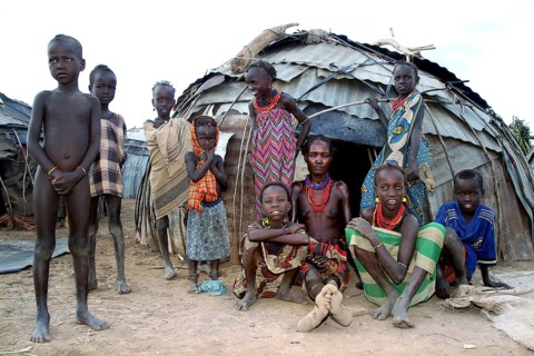 Woman and children in front of traditional huts in a village in Omorate, Omorate, Ethiopia
