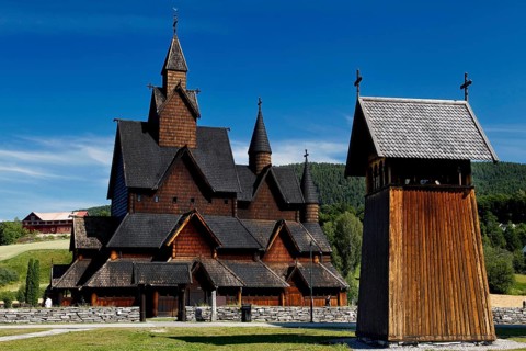 Heddal stave church with free-standing bell tower under clear sky, Heddal, Notodden, Norway