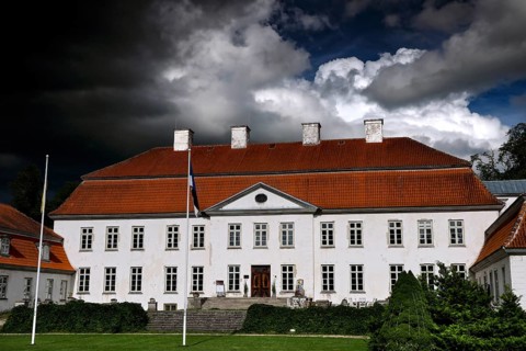 Large historic manor house with dramatic cloudy sky, Suuremäisa, Hiiumaa, Estonia