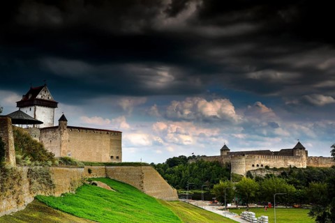 View of Hermann Fortress and Ivangorod in Narva with dramatic clouds in the sky, Narva, Estonia