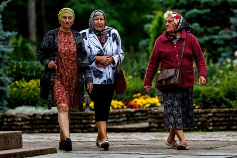 Three woman wearing headscarves stroll through the garden in Kuremäe, Kuremäe, Pühtitsa, Estonia