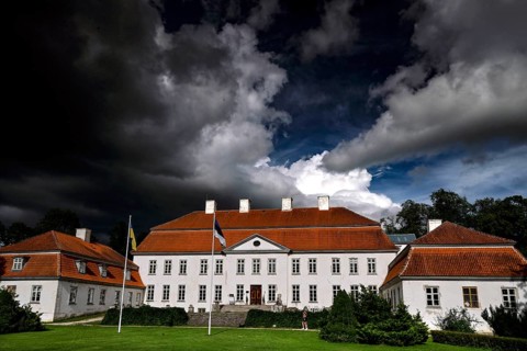 Historic manor house with red roofs under dramatic sky, Suuremäisa, Hiiumaa, Estonia