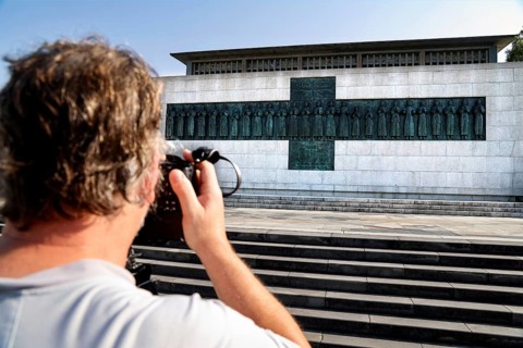 Martyr memorial with a photographer in the foreground, steps leading to the impressive building,