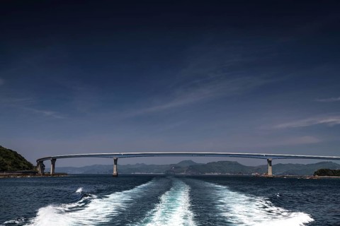 Bridge spanning the sea, with wave patterns in the foreground under clear sky, Nagasaki, Nagasaki,