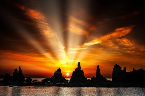 Impressive sunbeams over rock formations at dawn, Kushimoto, Japan