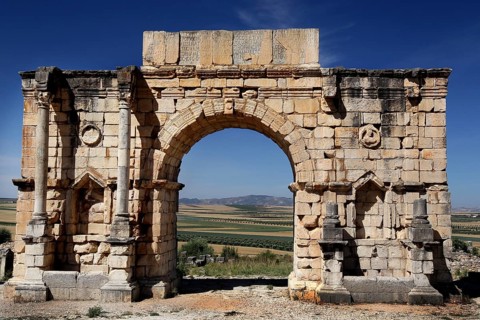 Preserved Roman triumphal arch with ancient stone reliefs in the ruins of Volubilis, Volubilis,