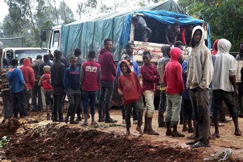 Group of people gather around a truck on a muddy road, Yirga Alem, Yabello, Ethiopia